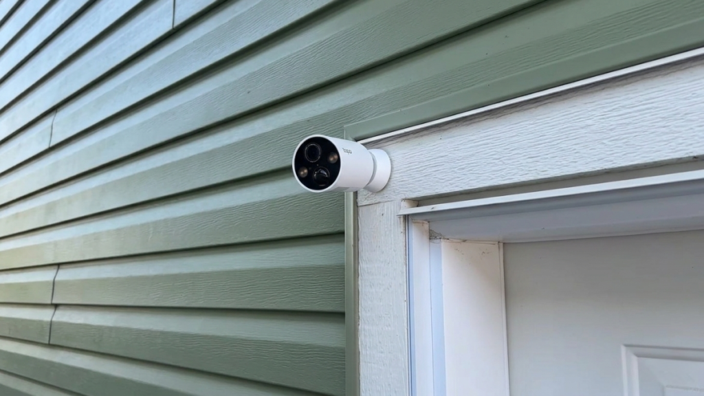 Tapo MagCam 2K+ wireless outdoor security camera mounted above an exterior door on house siding