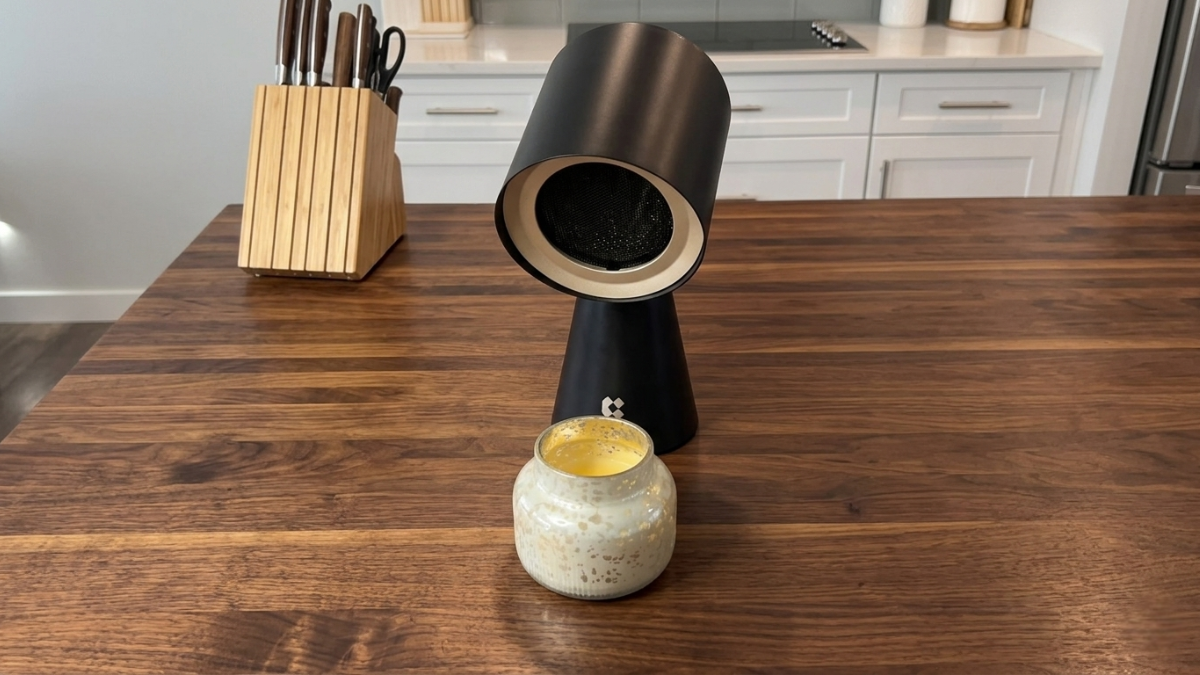 Portable range hood placed on a kitchen countertop beside a candle and knife block